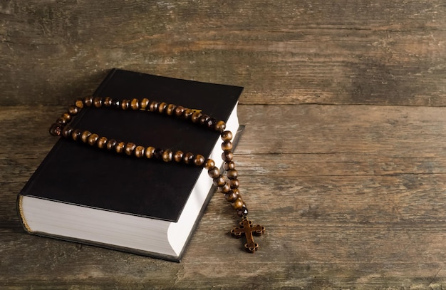 Premium Photo | Bible with rosary on old wooden background with copy