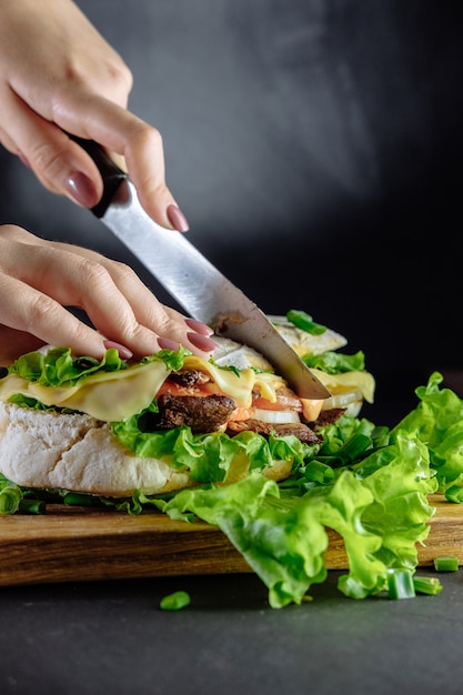 Bolshoj Sendvich Strit Fast Fud Domashnie Kotlety S Govyadinoj Syr Na Derevyannyj Stol Tonirovannoe Image Chef Rezhet Nozh Dlya Sendvicha Premium Foto