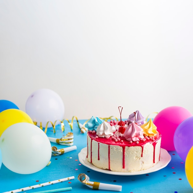 Birthday cake and colorful balloons Free Photo