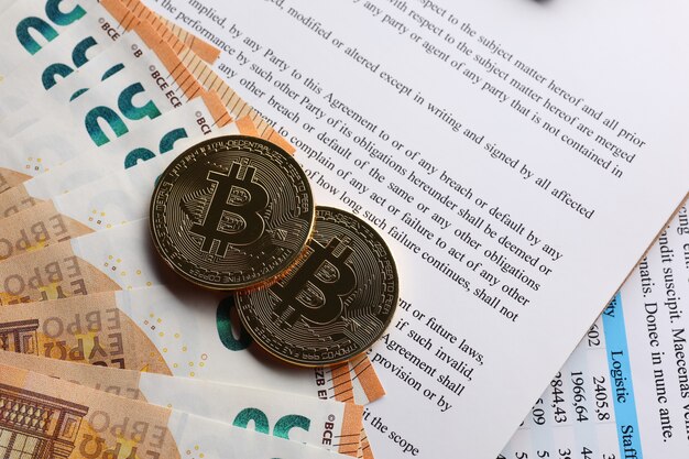 Premium Photo | Bitcoins on document and banknotes