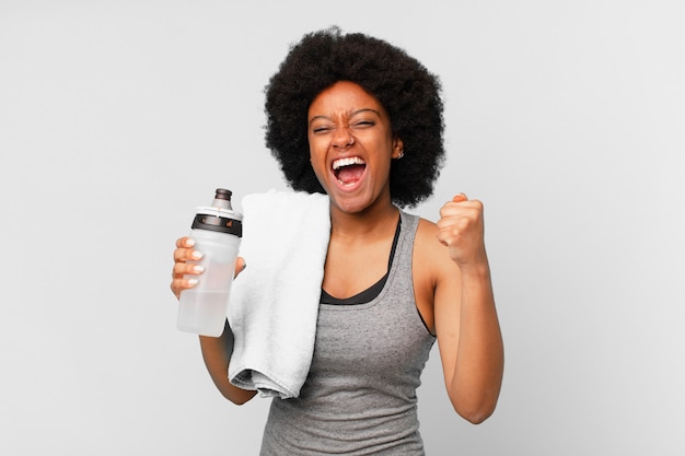 Premium Photo | Black afro fitness woman with a towel and water can