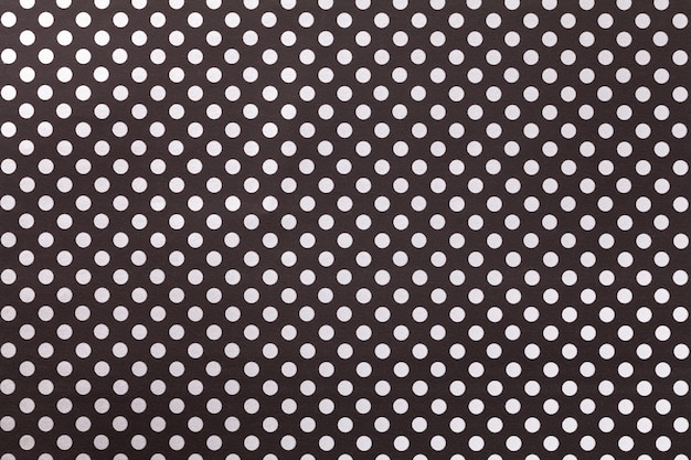 Black background from wrapping paper with a pattern of white polka dot closeup. Premium Photo