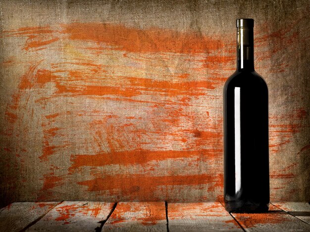 Premium Photo | Black bottle of wine on the background of the canvas