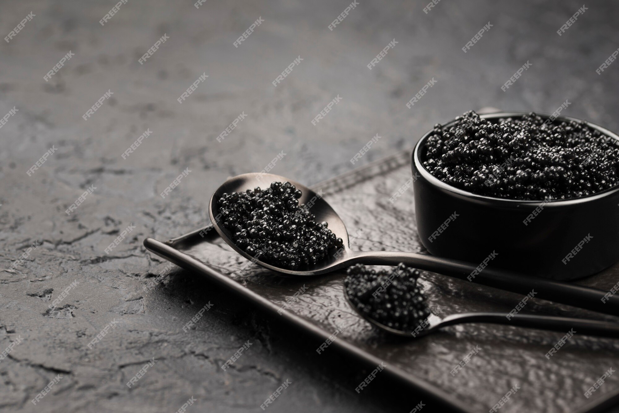 Free Photo | Black caviar in bowl with spoons and ladle