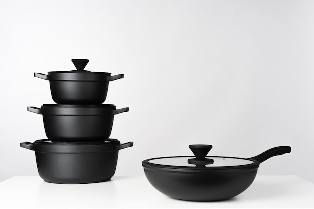 Premium Photo | Black cooking pots on grey background front view close up