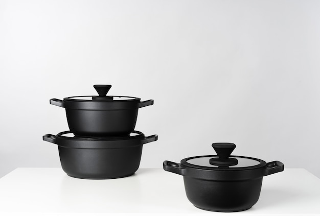 Premium Photo | Black cooking pots on grey background front view