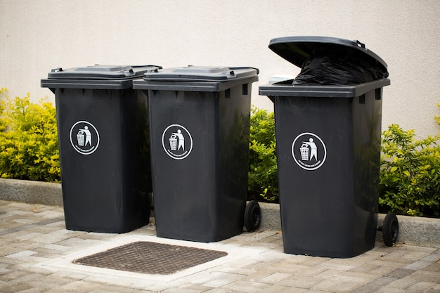 Black indoor waste containers for recycling and garbage. a ...