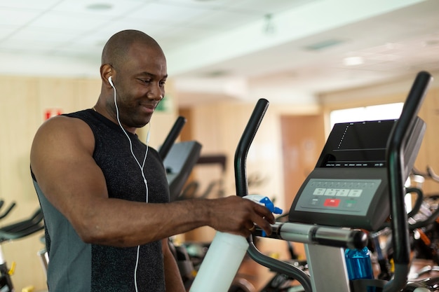 Premium Photo | Black male athlete cleaning a cardio machine with ...