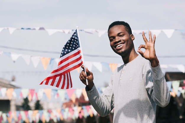 black-man-holding-american-flag-looking-camera-with-gesture-ok_23-2148166065.jpg