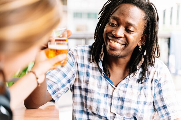 ドレッドヘアを持つ黒人男性 ビールで乾杯 プレミアム写真