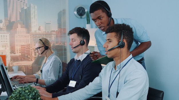 Premium Photo | Black manager operator helping his colleague in call center