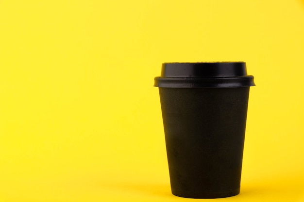 Download Premium Photo | Black paper eco cup, coffee paper cup on yellow background. mockup for your ...