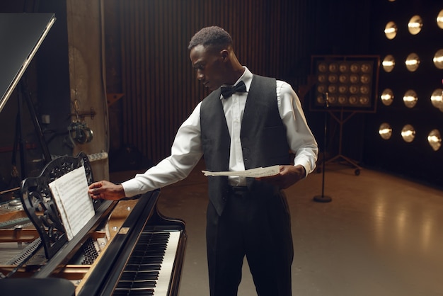 Premium Photo | Black pianist with music notebook in his hands on the ...