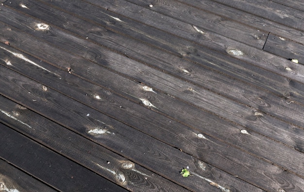 川沿いの桟橋だけで作られた黒い板 建設用の古い湿った木のクローズアップ プレミアム写真