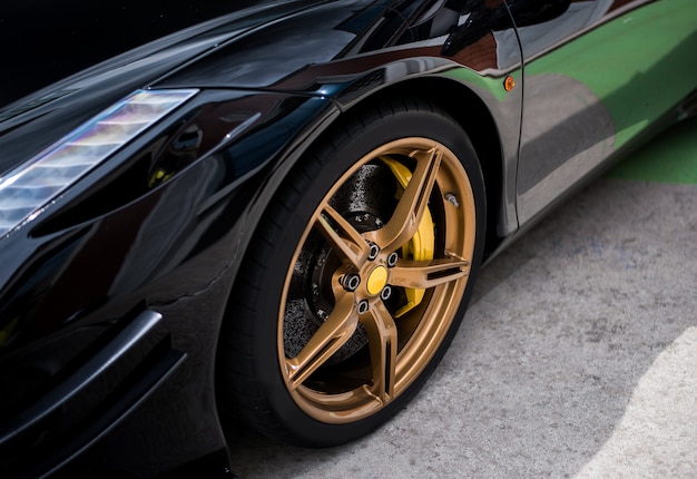 Black sedan car wheel with golden, bronze color decoration. Free Photo