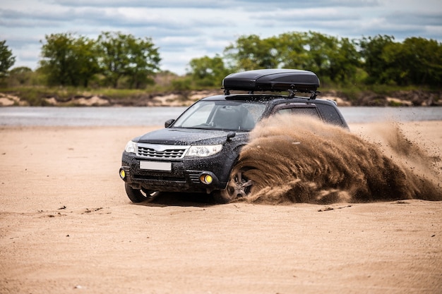 Premium Photo | Black subaru forester moving on sand beach sand flying ...