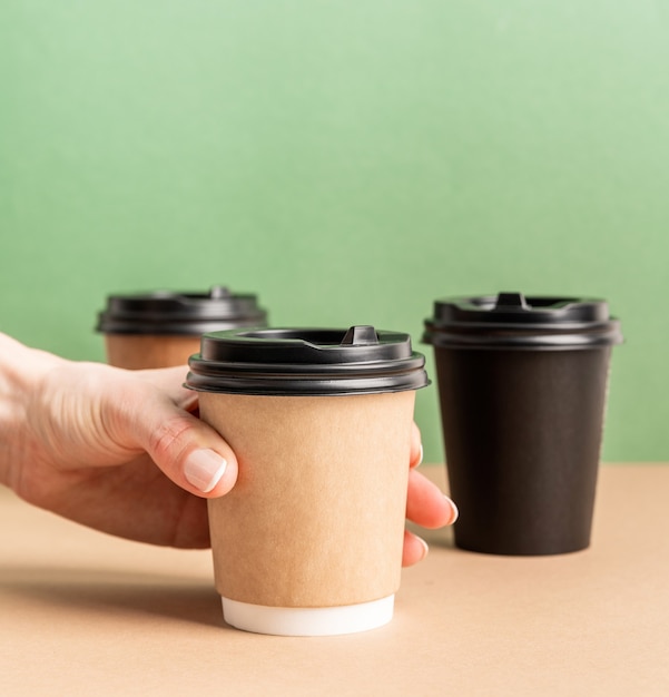 Premium Photo | Black takeaway paper coffee cups mock up on green and ...