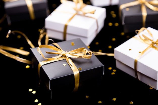 Premium Photo | Black and white gift boxes with gold ...