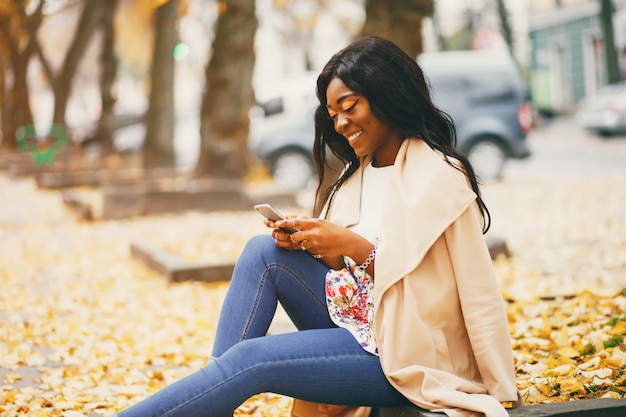 Free Photo  Black woman sitting in a autumn city