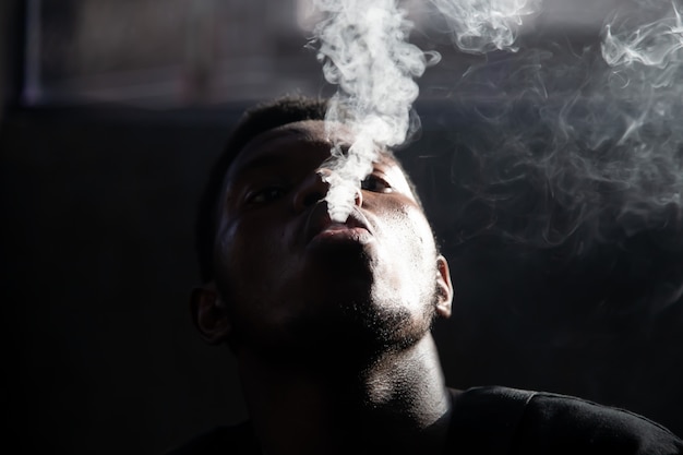 Premium Photo | Black young man smoking and blowing up the smoke