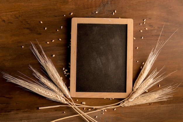 Blackboard and spike wheat on brown wooden table Free Photo