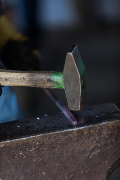 Premium Photo | A blacksmith forging hot iron on the anvil.