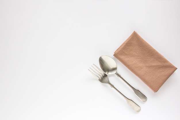 Blank brown restaurant napkin mockup with spoon and fork | Premium Photo