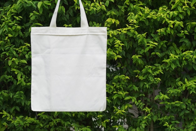 Premium Photo | Blank fabric bag hanging on green leaf