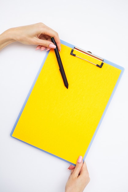 Premium Photo | Blank folder with yellow paper, hand that holding ...