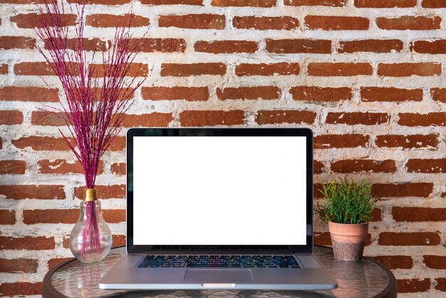 Blank Screen Of Laptop Computer On Table With Red Brick Wall Photo