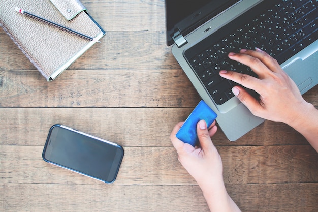 Blank screen smartphone for application mock up with man using credit card and laptop computer Premium Photo