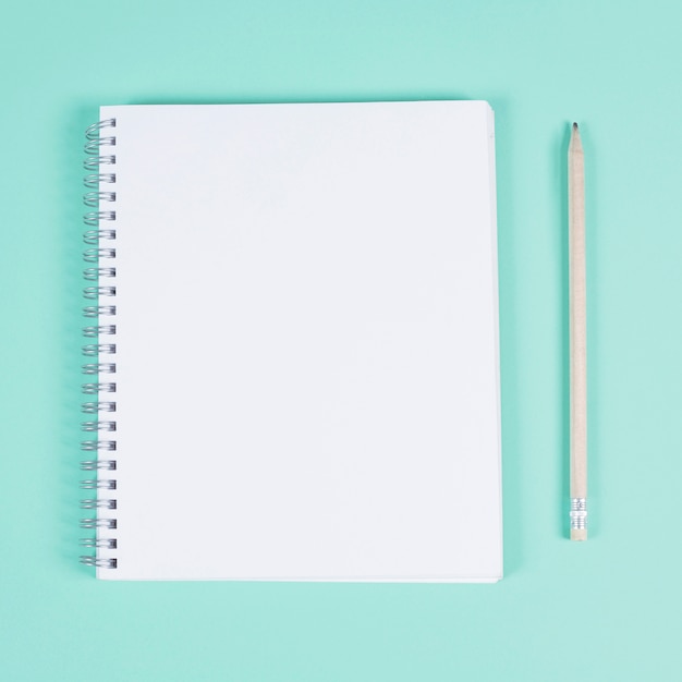 Download Blank spiral notebook with pencil on turquoise background ...