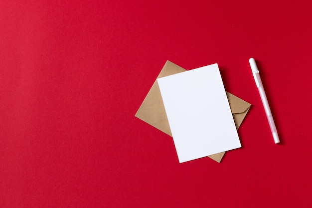 Blank white card with pen. empty white paper sheet isolated on red background Premium Photo
