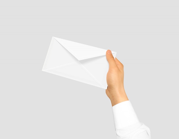 Blank white envelope mock up holding in hand. Premium Photo