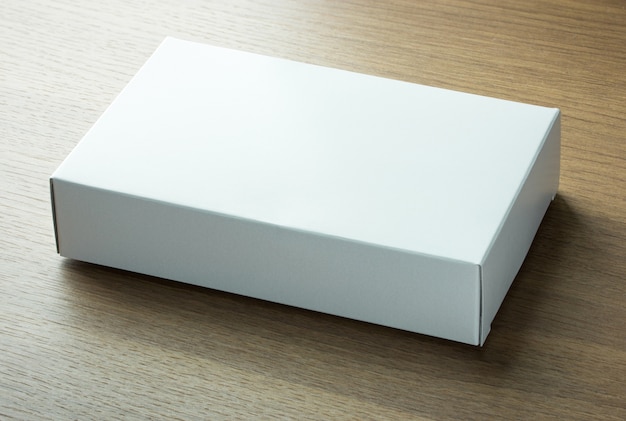 Blank white paper box on dark wood background | Free Photo