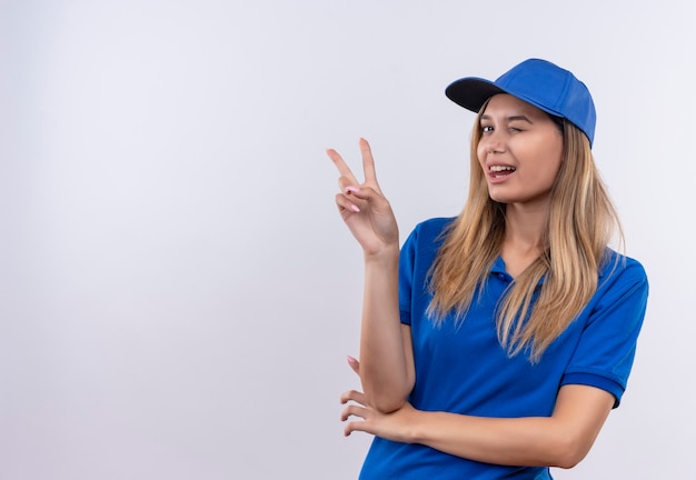 Free Photo | Blinked young delivery girl wearing blue uniform and cap ...