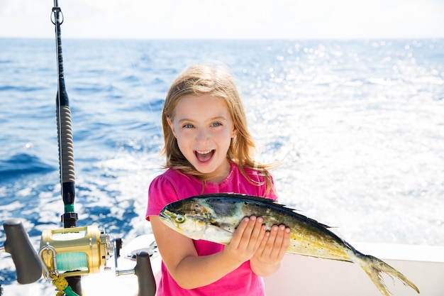 金髪の子供女の子釣りドラドマヒマヒ魚ハッピーキャッチ  プレミアム写真