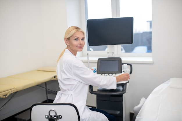 Premium Photo | Blond pretty ultrasound specialist in white robe ...