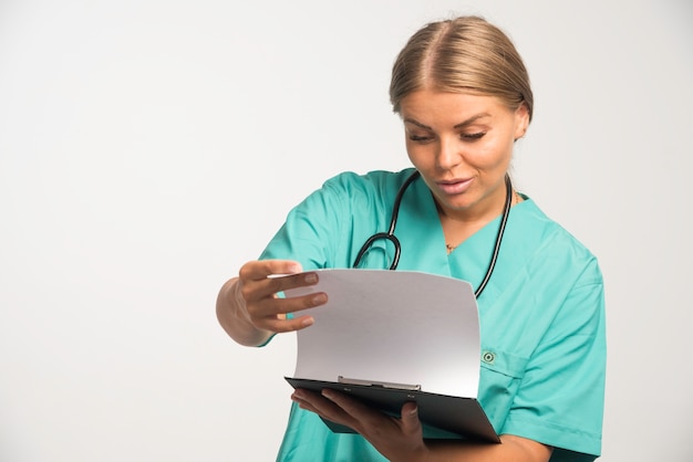 Free Photo Blonde Female Doctor In Blue Uniform Checking The History