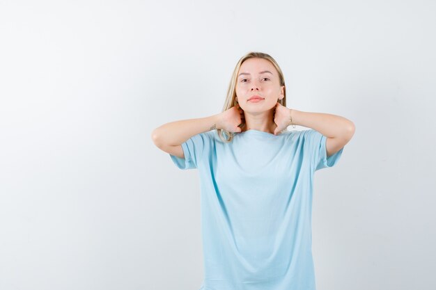 首に手をつないで真剣に見える青いtシャツのブロンドの女の子 正面図 無料の写真