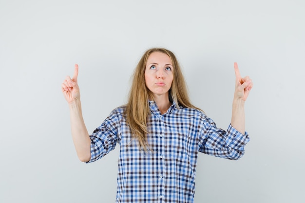 Free Photo | Blonde lady in shirt pointing up and looking hopeful