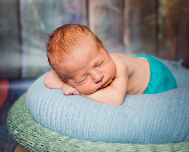 Blonde newborn baby sleeps on soft blue pillow Photo Free Download