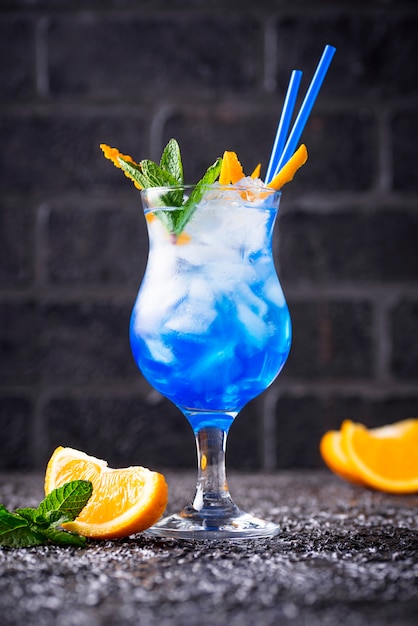 Blue cocktail drink with ice and orange | Premium Photo