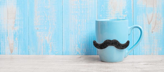 Premium Photo Blue Coffee Cups With Black Mustache On Wood Table Background In The Morning 