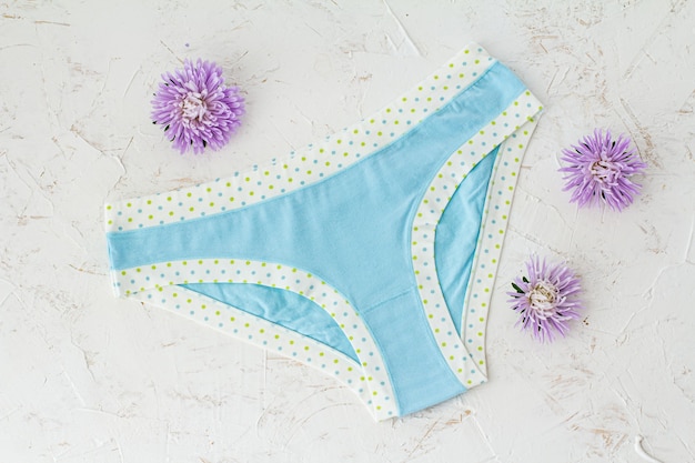 Premium Photo | Blue cotton panties with flower buds on the white ...