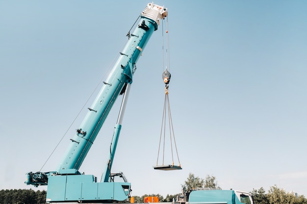 Premium Photo | Blue crane lifting mechanism with hooks