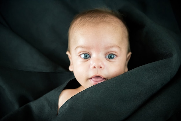 Premium Photo Blue Eyed Naked Baby Lying On Black Fabric