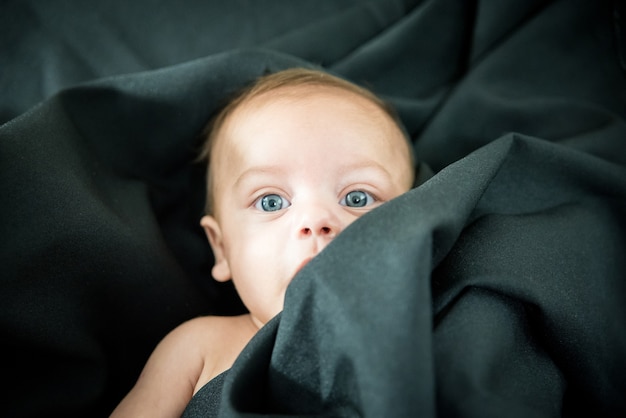 Premium Photo Blue Eyed Naked Baby Lying On Black Fabric