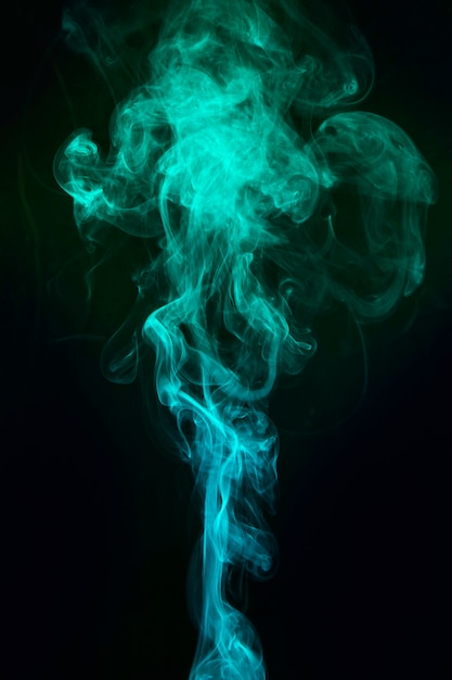 Free Photo | Blue and green smoke spread over black background