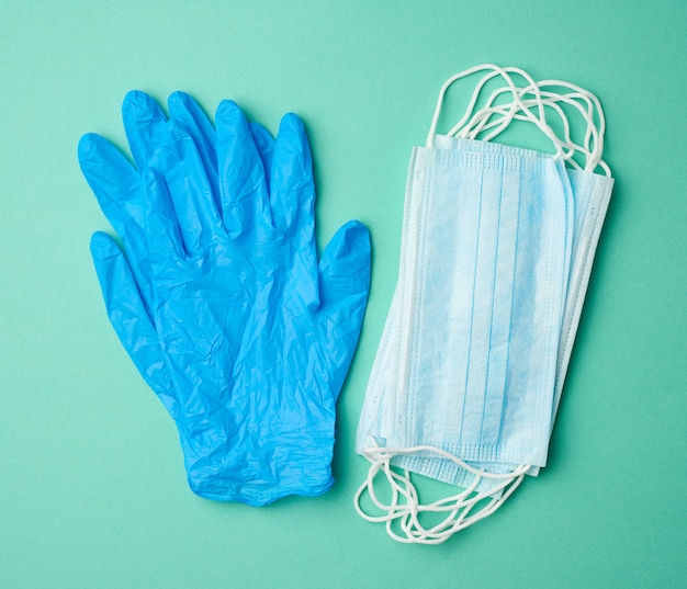 Premium Photo | Blue latex gloves and disposable masks on a green ...